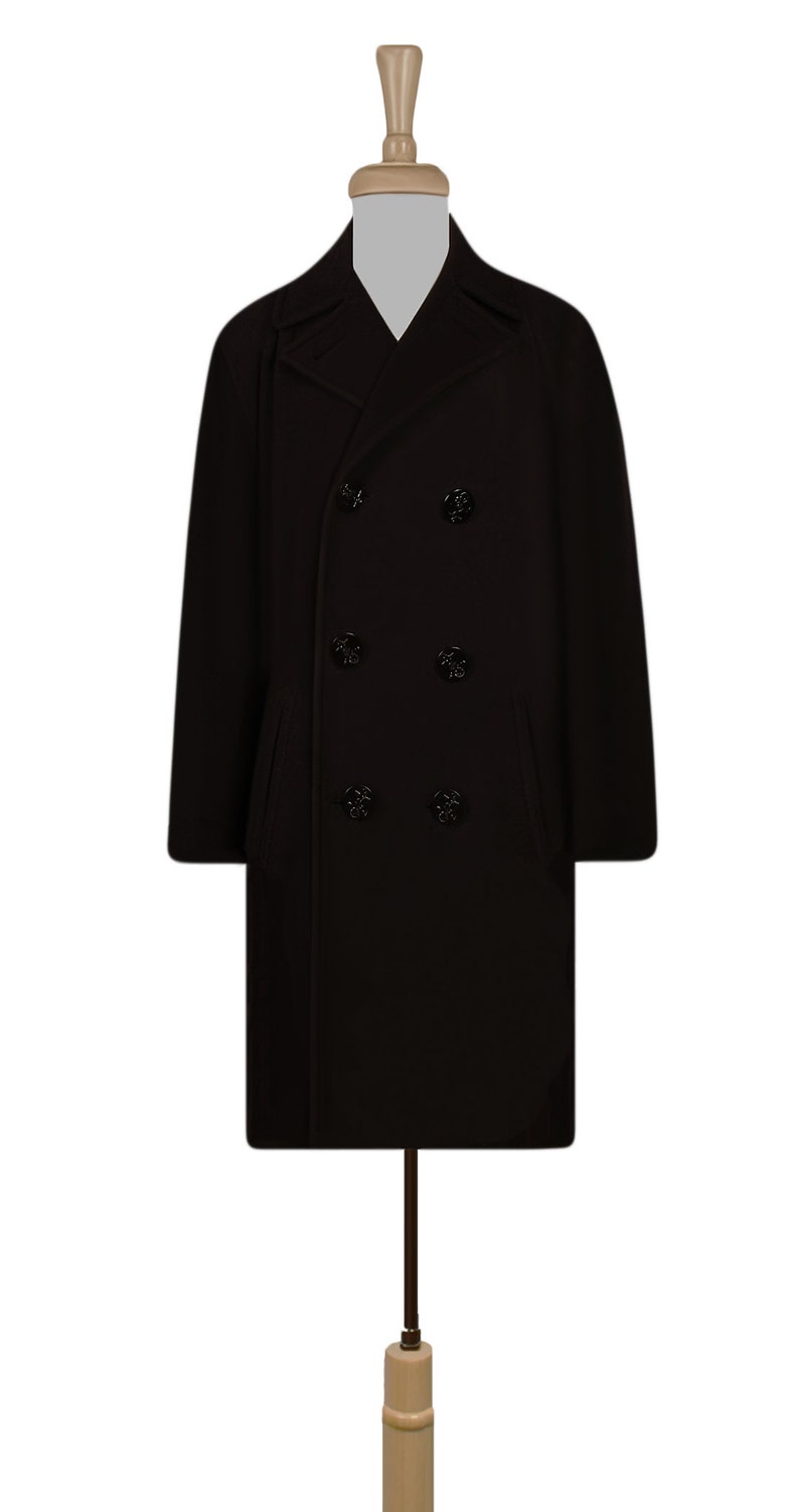 K&ouml;nnte beinhalten: Ein schwarzer, zweireihiger Peacoat mit klassischem Design. Der Mantel hat sechs schwarze Kn&ouml;pfe und zwei Eingrifftaschen.
