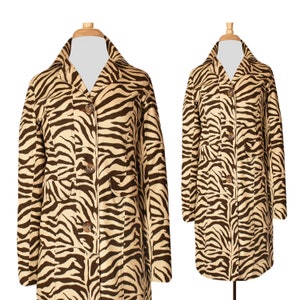 May include: A long-sleeved zebra print jacket with a button-up front and two pockets. The jacket is brown and beige.