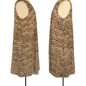 May include: A sleeveless dress with a leopard print pattern. The dress is a light brown color with dark brown spots. The dress is on a mannequin.