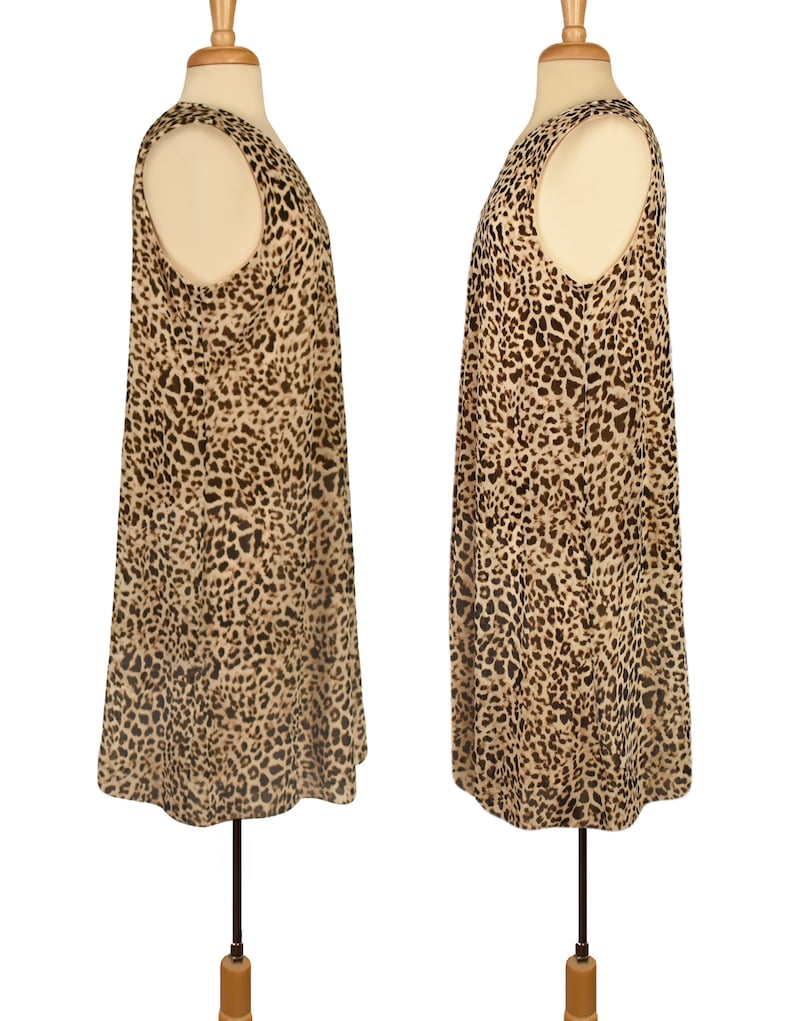 May include: A sleeveless dress with a leopard print pattern. The dress is a light brown color with dark brown spots. The dress is on a mannequin.