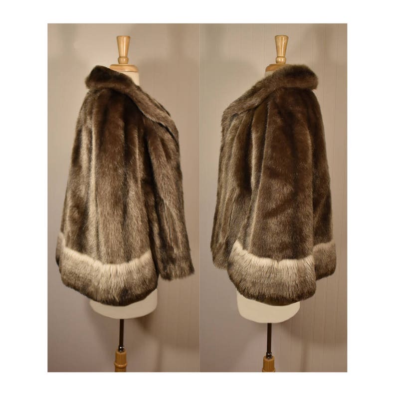 Peut inclure: Une veste en fausse fourrure marron avec une bordure blanche autour du bas et des manches. La veste est expos&eacute;e sur un mannequin.