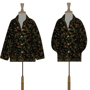 May include: Two black floral patterned jackets on mannequins. The jackets have a button-up front and long sleeves.