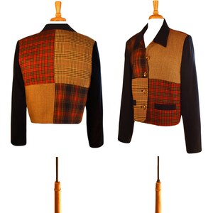 May include: A cropped jacket with a patchwork design. The jacket is made of four different plaid fabrics in shades of red, black, brown, and tan. The jacket has a navy blue collar and cuffs.