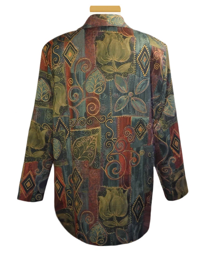 May include: A long-sleeved, patterned blazer in shades of teal, burgundy, and olive green. The fabric features a repeating design of stylized flowers, leaves, and geometric shapes outlined in gold. The blazer has a collared neckline.