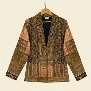 Op de afbeelding: Een bruin, groen en beige gepatroneerd blazer met een enkele knoopsluiting en een shawlkraag. De blazer heeft een patchwork-design met bloemenpatronen.