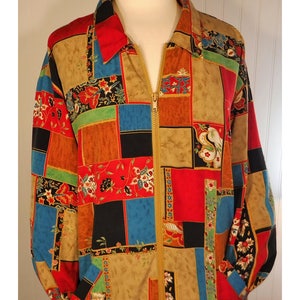 May include: A long-sleeved jacket with a zipper closure. The jacket is made of a patchwork fabric with a variety of colors and patterns, including red, blue, green, and brown. The fabric has a floral design.
