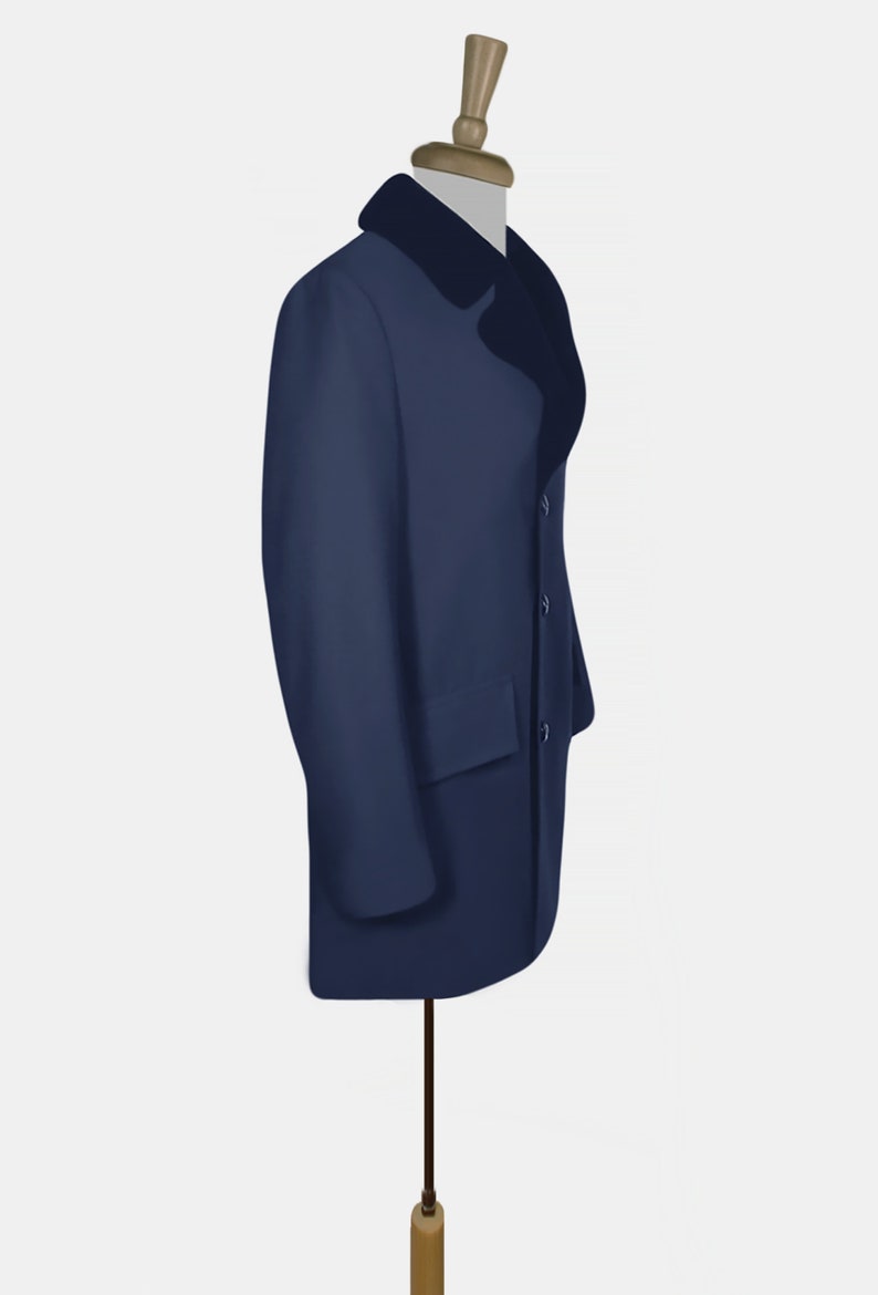 K&ouml;nnte beinhalten: Ein marineblauer Mantel mit schwarzem Pelzkragen. Der Mantel befindet sich auf einem Mannequin und hat einen einzigen Knopfverschluss.