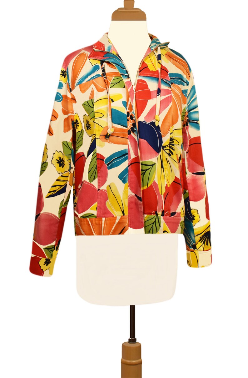 May include: A white jacket with a colorful floral print. The jacket has a zipper closure and a hood.