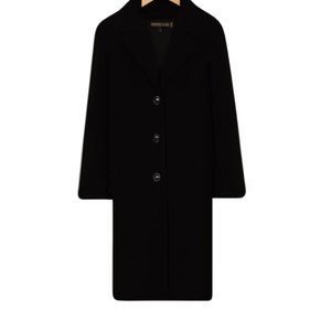 May include: A black long-sleeved coat with a collar and four buttons down the front.