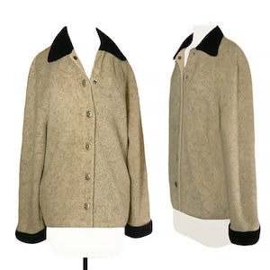May include: A beige fleece jacket with a black velvet collar and cuffs. The jacket has a button front closure and a slightly cropped length.