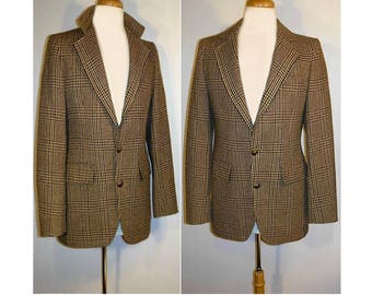 May include: A brown, black and beige plaid blazer with a two-button fastening. The blazer is on a mannequin and has a notched lapel.