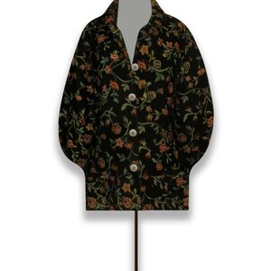 May include: A black jacket with a floral pattern in shades of orange, green, and yellow. The jacket has a button-up front and long sleeves.