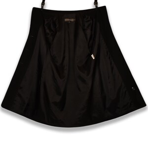 May include: Black wool coat with a satin lining. The coat has a button closure and a single button on the cuff.