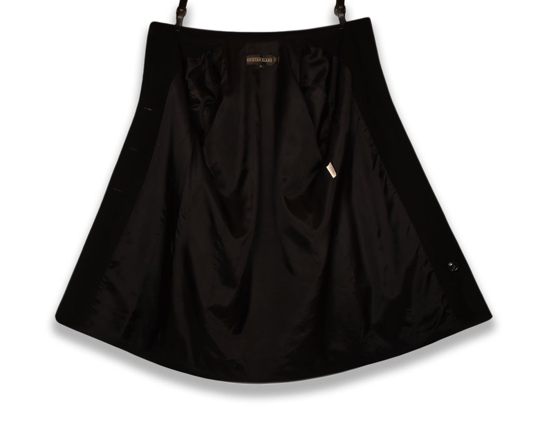 May include: Black wool coat with a satin lining. The coat has a button closure and a single button on the cuff.