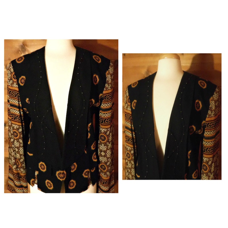 May include: A black blazer with a gold and brown patterned design on the sleeves. The blazer has a deep V-neck and a fitted silhouette.