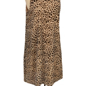 May include: A sleeveless dress with a leopard print pattern in shades of brown and tan. The dress is on a mannequin.