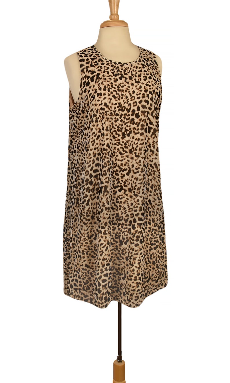 May include: A sleeveless dress with a leopard print pattern in shades of brown and tan. The dress is on a mannequin.