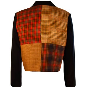 May include: A black blazer with a patchwork design on the back. The patchwork is made up of four different plaid fabrics in red, black, brown, and white.