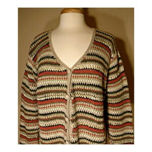 May include: A striped crocheted cardigan with a v-neck and button closure. The cardigan is made in shades of beige, green, and red.