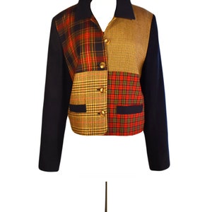 May include: A navy blue blazer with a patchwork design featuring red, yellow, and brown plaid patterns. The blazer has a collar and long sleeves.
