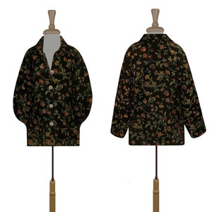 May include: A black long-sleeved shirt with a floral pattern in shades of orange, yellow, and green. The shirt has a button-up front and a collar.