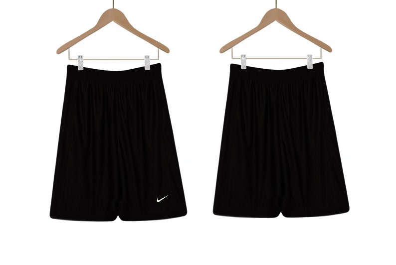 Puede incluir: Pantalones cortos deportivos negros con un logotipo blanco de Nike en forma de swoosh en la pierna derecha.