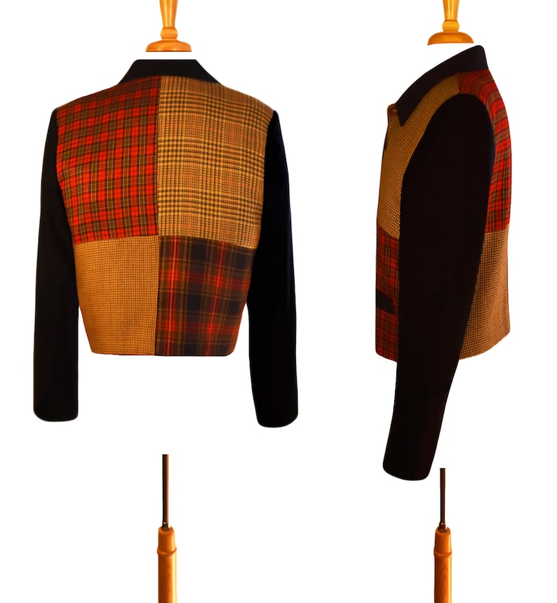 May include: A black cropped jacket with a patchwork design. The patchwork is made of four different plaid fabrics in shades of red, brown, and black.