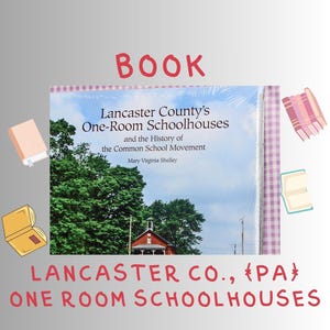 May include: A book titled "Lancaster County's One-Room Schoolhouses and the History of the Common School Movement" by Mary Virginia Shelley. The cover features a photo of a red schoolhouse and trees under a cloudy sky. The word "BOOK" is written in red.