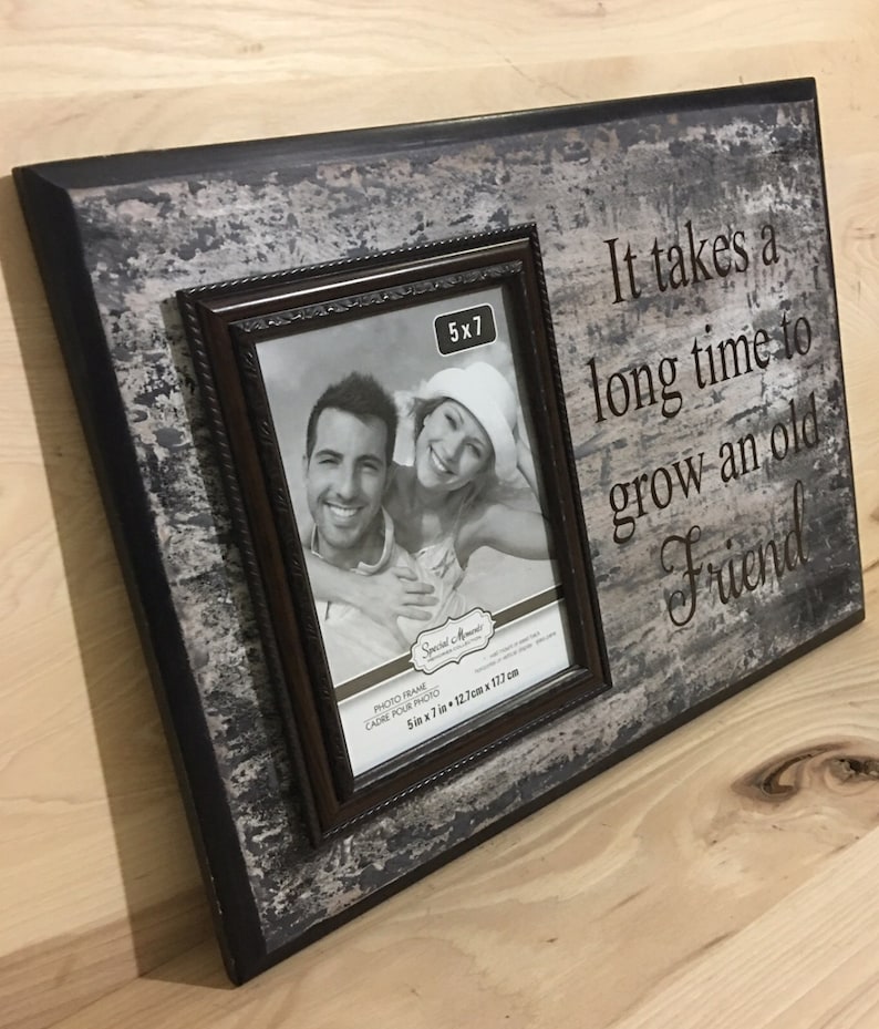 May include: A rustic wooden photo frame with a distressed gray and black finish. It holds a 5x7 inch photo and features the quote, "It takes a long time to grow an old Friend."