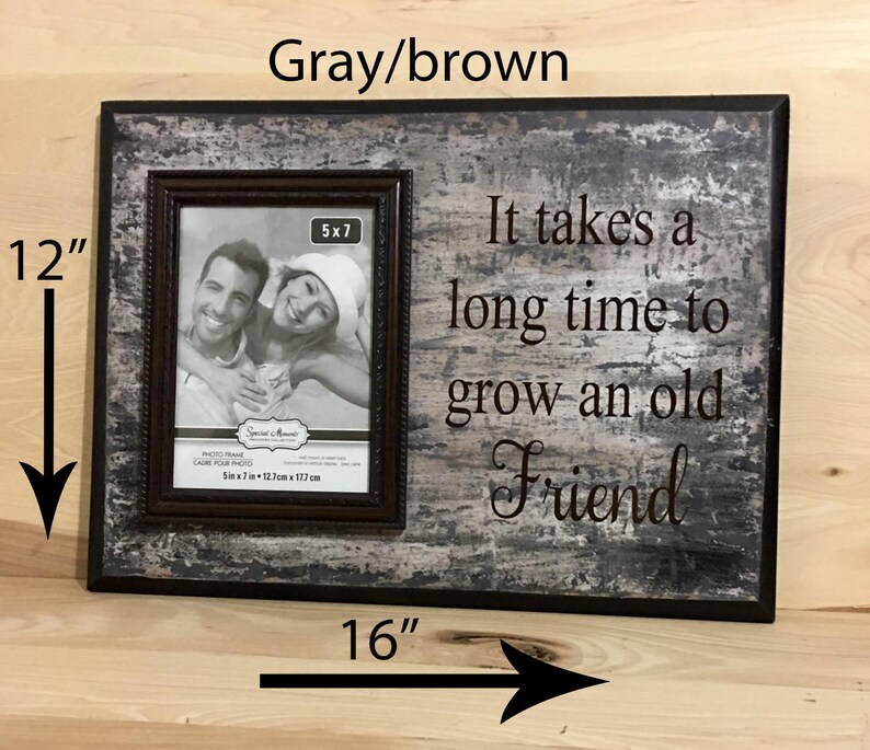 May include: A gray and brown wooden picture frame, 16 inches wide and 12 inches tall, with a 5x7 inch photo. The frame has the text "It takes a long time to grow an old Friend."