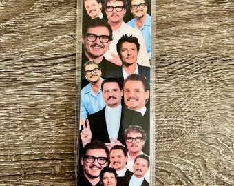 May include: A clear plastic bookmark with a collage of photos of a man with brown hair and a beard. The man is wearing glasses in most of the photos.