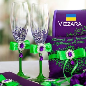 May include: Wedding decor set with purple and green accents. Two champagne flutes with purple and green designs, a pillow with the text "Michael and Jessica September 24, 2022", and a box with the text "Vizzara" and the Ukrainian flag.