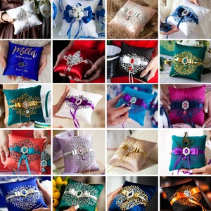 May include: A collection of decorative ring pillows in various colors and styles. The pillows feature different embellishments, including rhinestones, beads, and embroidery. Some pillows have a satin finish, while others have a velvet finish. The pillows are perfect for wedding ceremonies or other special events.