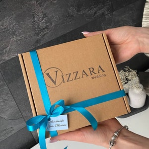 May include: A brown cardboard box with a blue ribbon and a tag that says "Handmade from Ukraine". The box is labeled "Vizzara Wedding".