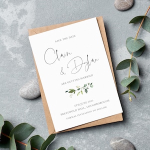 Pu&ograve; includere: Carta di salvataggio della data con sfondo bianco e illustrazione di fogliame verde. La carta recita "Save the Date, Claire & Dylan si sposano, 6 giugno 2025, Prestwold Hall, Loughborough, Invito formale a seguire."