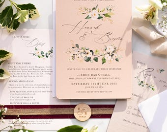 May include: Wedding invitation suite featuring a blush pink invitation card with floral accents and elegant script. Includes RSVP cards, details card, and a wooden embellishment. The invitation is for a wedding on June 14, 2025.