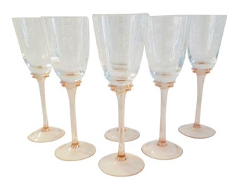 May include: Set of six clear glass wine glasses with pink stems and bases.