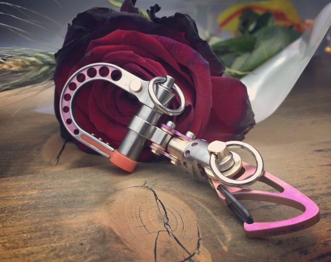 The guide Pink - TOP / Titanium Edc Keychain Bi-Carabiner, with swivel takes turns.