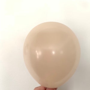 May include: A single, cream-colored balloon.
