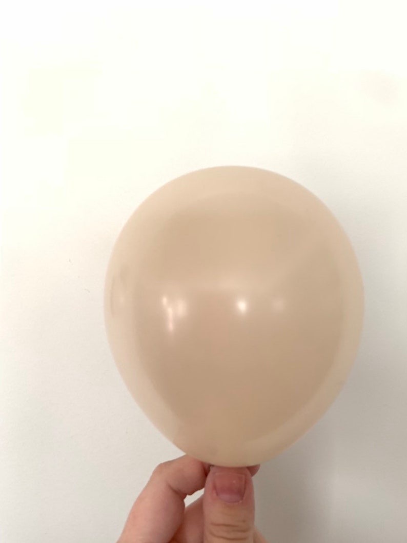 May include: A single, cream-colored balloon.