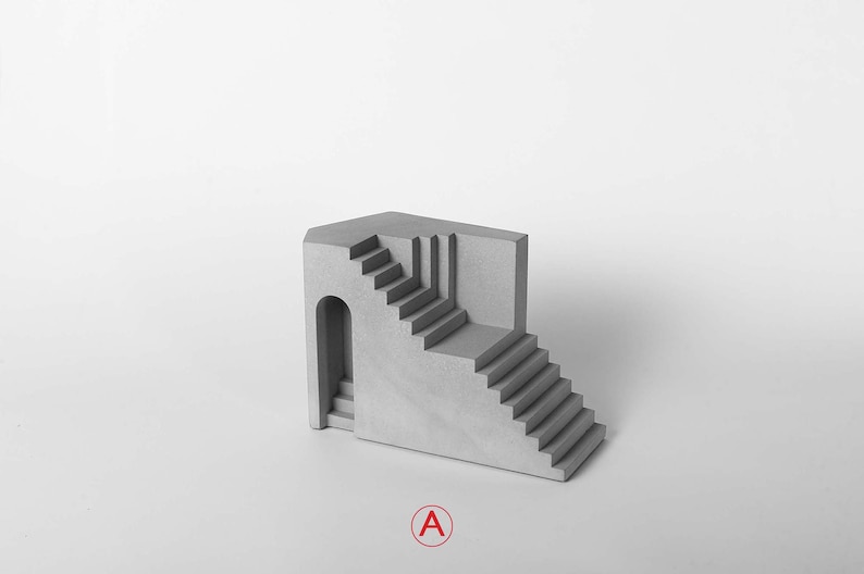 Puede incluir: Una escultura de hormig&oacute;n gris de un edificio con una escalera y una puerta arqueada. La escultura es de dise&ntilde;o moderno y minimalista.