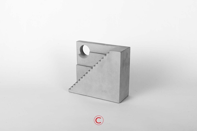 Puede incluir: Una escultura de hormig&oacute;n gris de un edificio con una escalera y una abertura circular. La escultura est&aacute; sobre un fondo blanco.