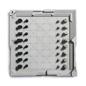 May include: A modern chess set with a gray board and black and white pieces. The board has a geometric design with a grid pattern. The chess pieces have a unique, abstract design. The set is displayed on a white background.