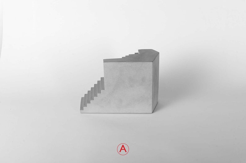 Puede incluir: Una escultura de hormig&oacute;n gris de una escalera con una esquina, sobre un fondo blanco.