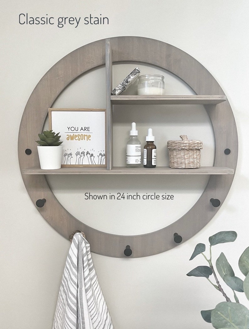May include: A round wooden shelf with three shelves and hooks, painted in a classic grey stain. The shelf is 24 inches in diameter and features a sign that says "You are awesome".