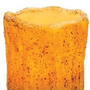 May include: A cylindrical candle with a textured, speckled surface. The candle has a warm, amber color that fades from a darker shade at the base to a lighter hue at the top. The candle's edges have a slightly uneven, rustic appearance.