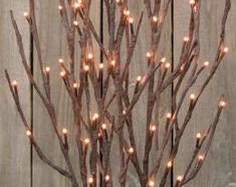May include: Brown decorative branches with small, warm white LED lights. The branches are arranged in a vertical display, creating a natural and rustic aesthetic. The lights are evenly spaced, providing a soft, ambient glow. Perfect for home decor.
