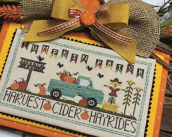 May include: Cross stitch pattern featuring a vintage truck with pumpkins, a scarecrow, and the text "Pumpkin Patch Harvest Cider Hayrides". The pattern is titled "Pumpkin Patch" and is designed by Katie Rogers.