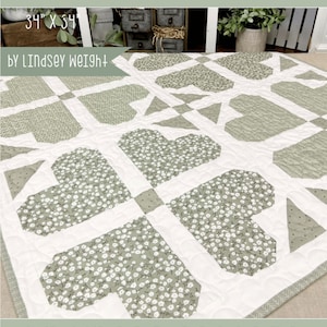 May include: A quilt pattern called "Farmhouse Flowers" by Lindsey Weight. The quilt is 34 inches by 54 inches and features a green and white floral print with a heart design. The quilt is called "Primrose Cottage".
