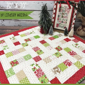 Pode incluir: Uma colcha de retalhos vermelha, verde e branca com o título "Scattershot" e o subtítulo "Primrose Cottage". A colcha mede 76 cm por 76 cm.